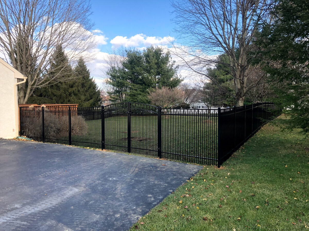 Ornamental aluminum fence with arched double gate in yard