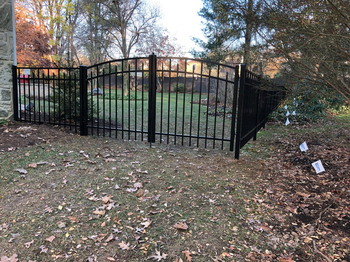 Ornamental aluminum fence with arched double gate in yard