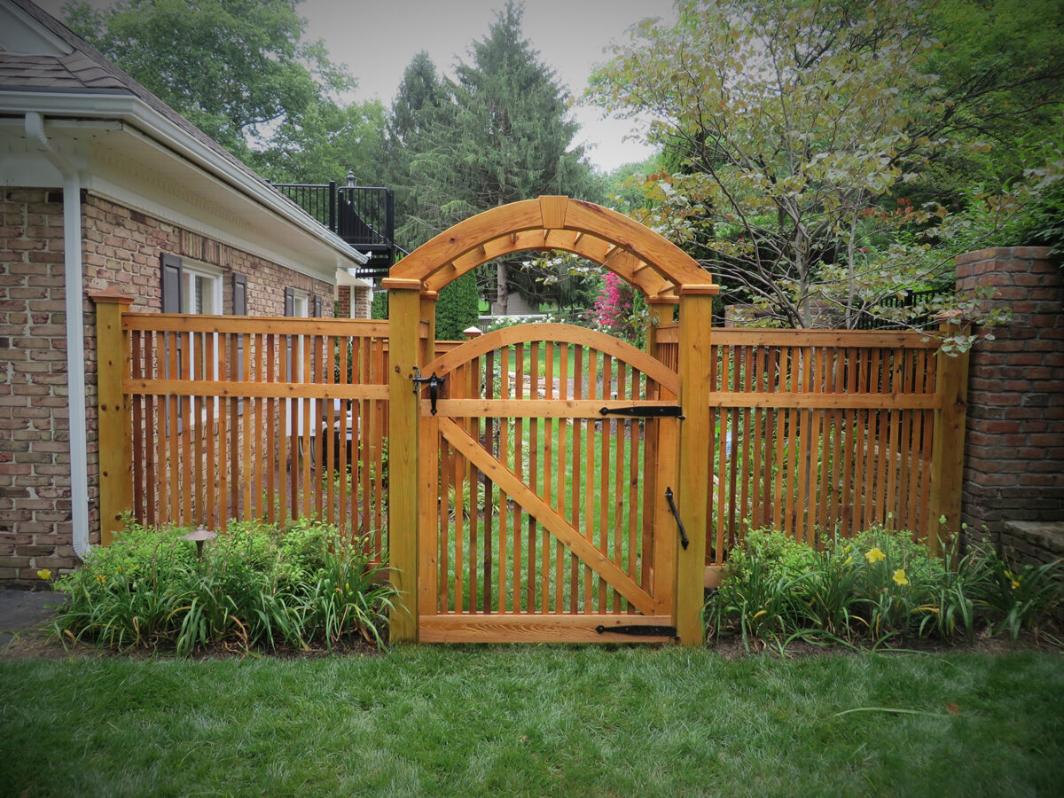 wooden semi-private fence with arched gate and arbor