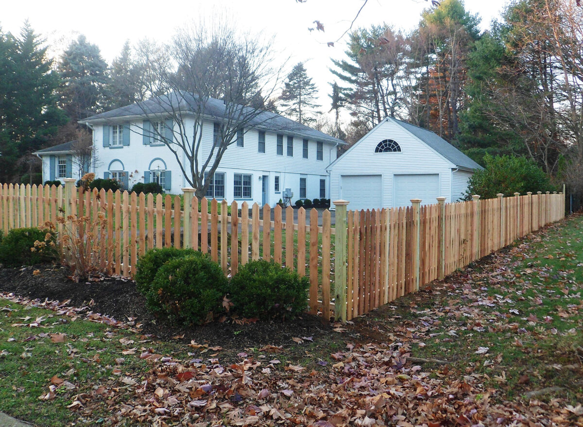 wood picket fence with post caps around yard