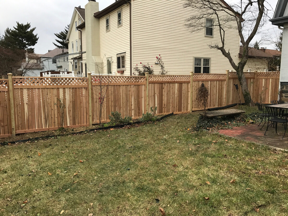 Framed red cedar privacy fence in yard with lattice top