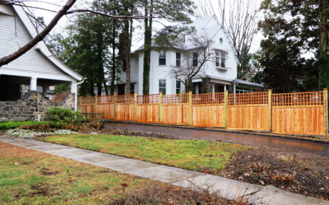 Framed wood privacy fencing with lattice beside drive