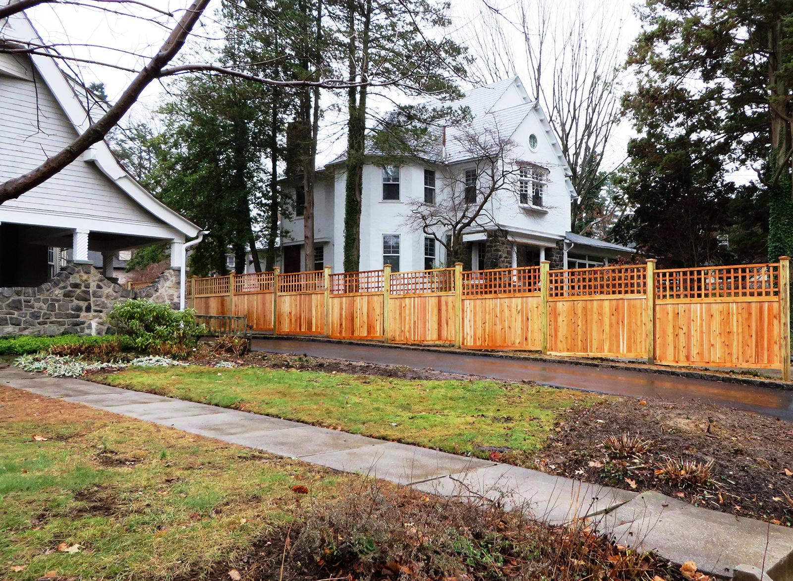 Framed wood privacy fencing with lattice beside drive