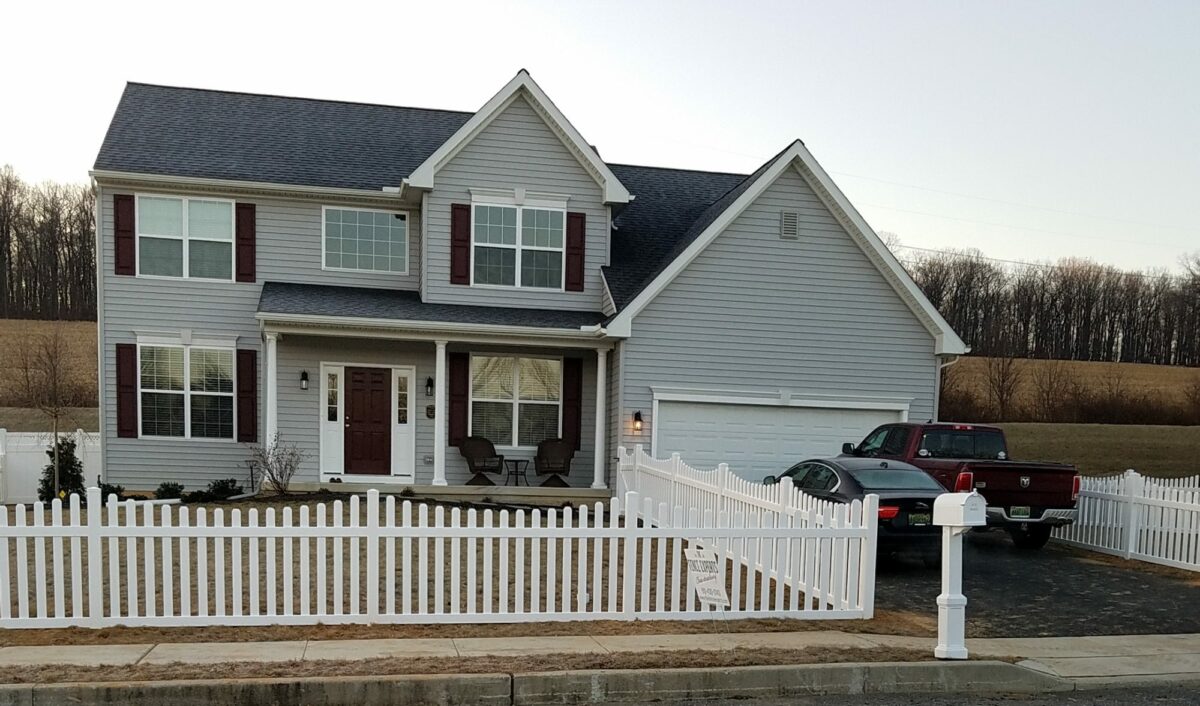white vinyl picket fence with concaved top in front of house