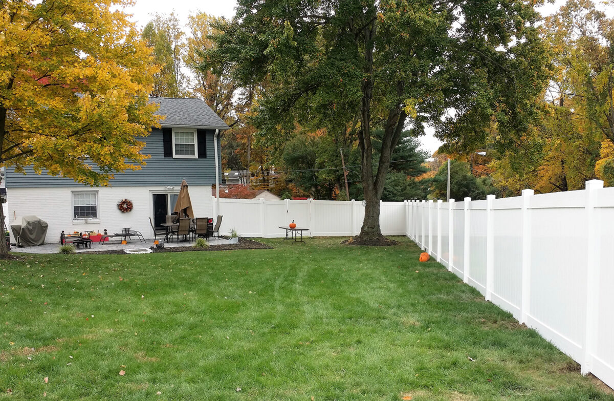 white vinyl privacy fence in backyard