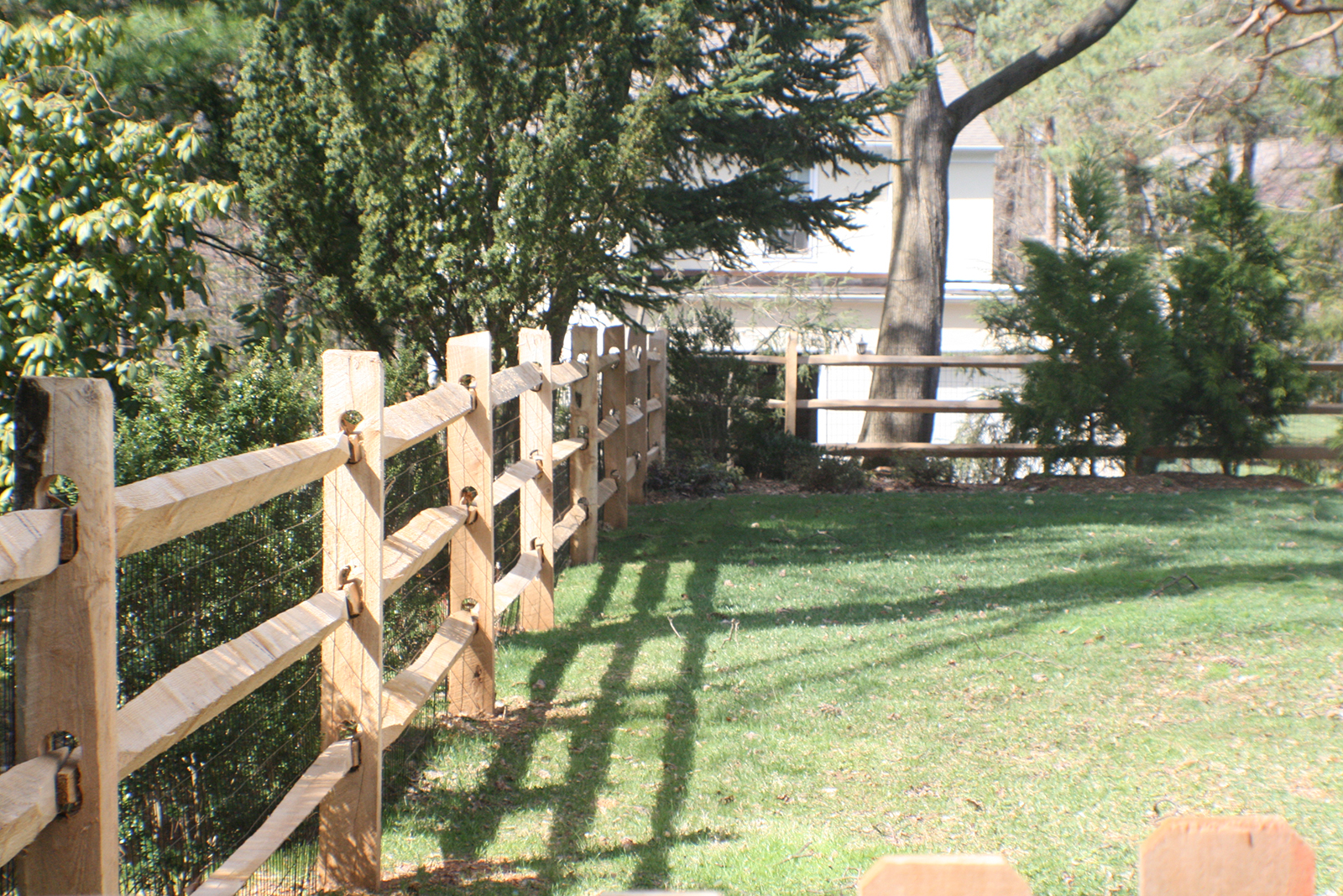 3-rail split-rail fence with wire mesh to protect pets in yard