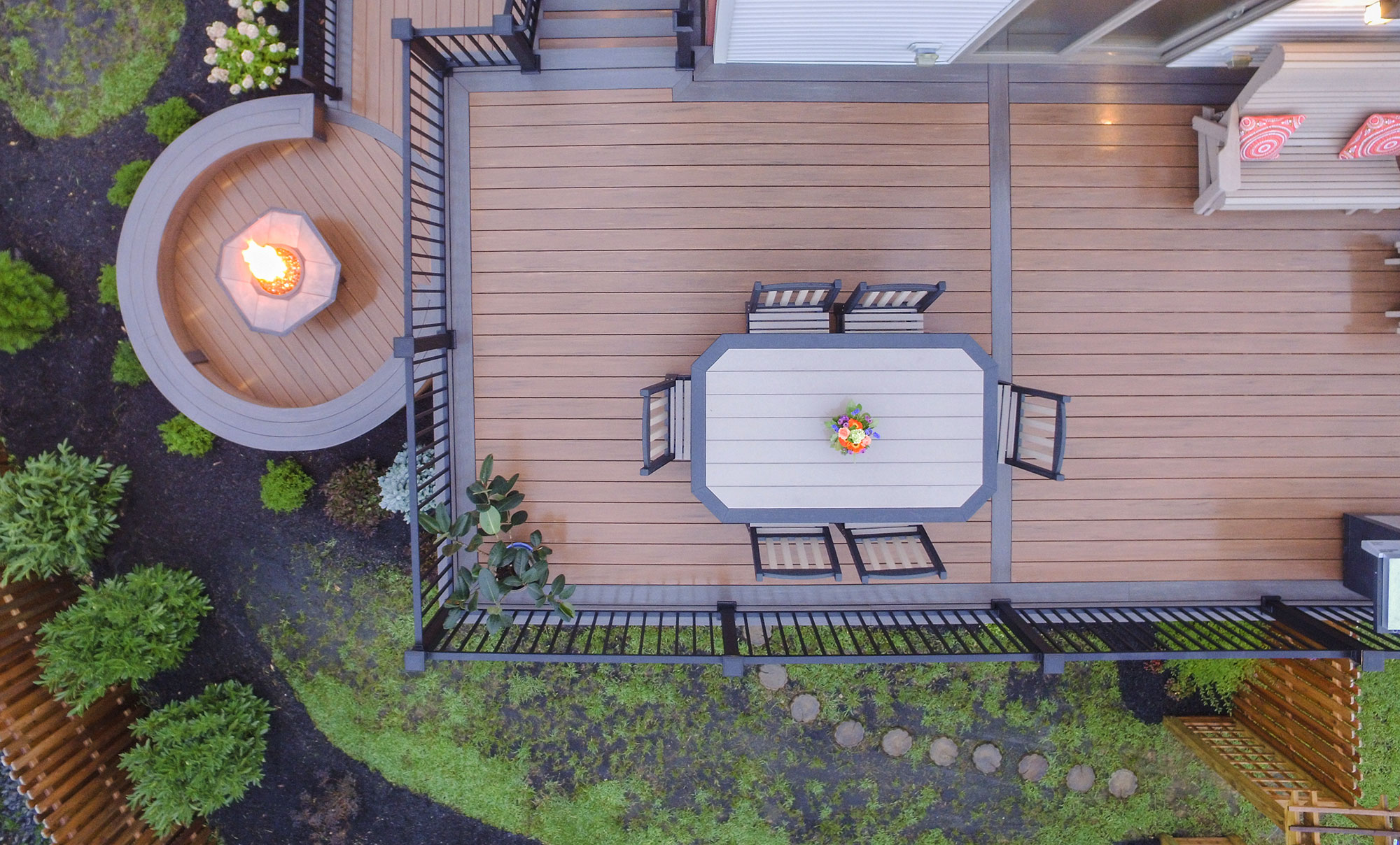 Aerial photo of backyard deck with fire pit and dining table