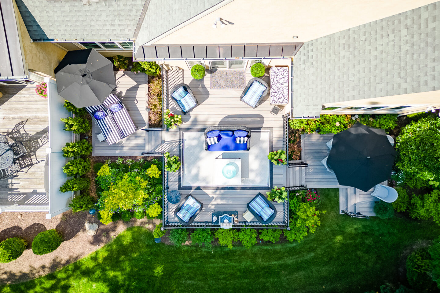 image of a backyard with a multilevel timbertech deck built by integrous fences and decks it is surrounded by beautiful landscaping