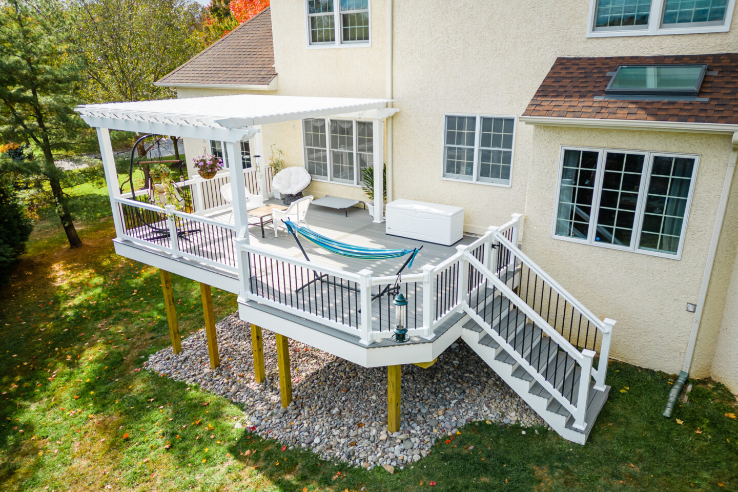 image of a deck with pergola in newtown square pa built by integrous fences and decks featuring a white vinyl pergola sea salt timbertech decking white vinyl railing with black aluminum railing
