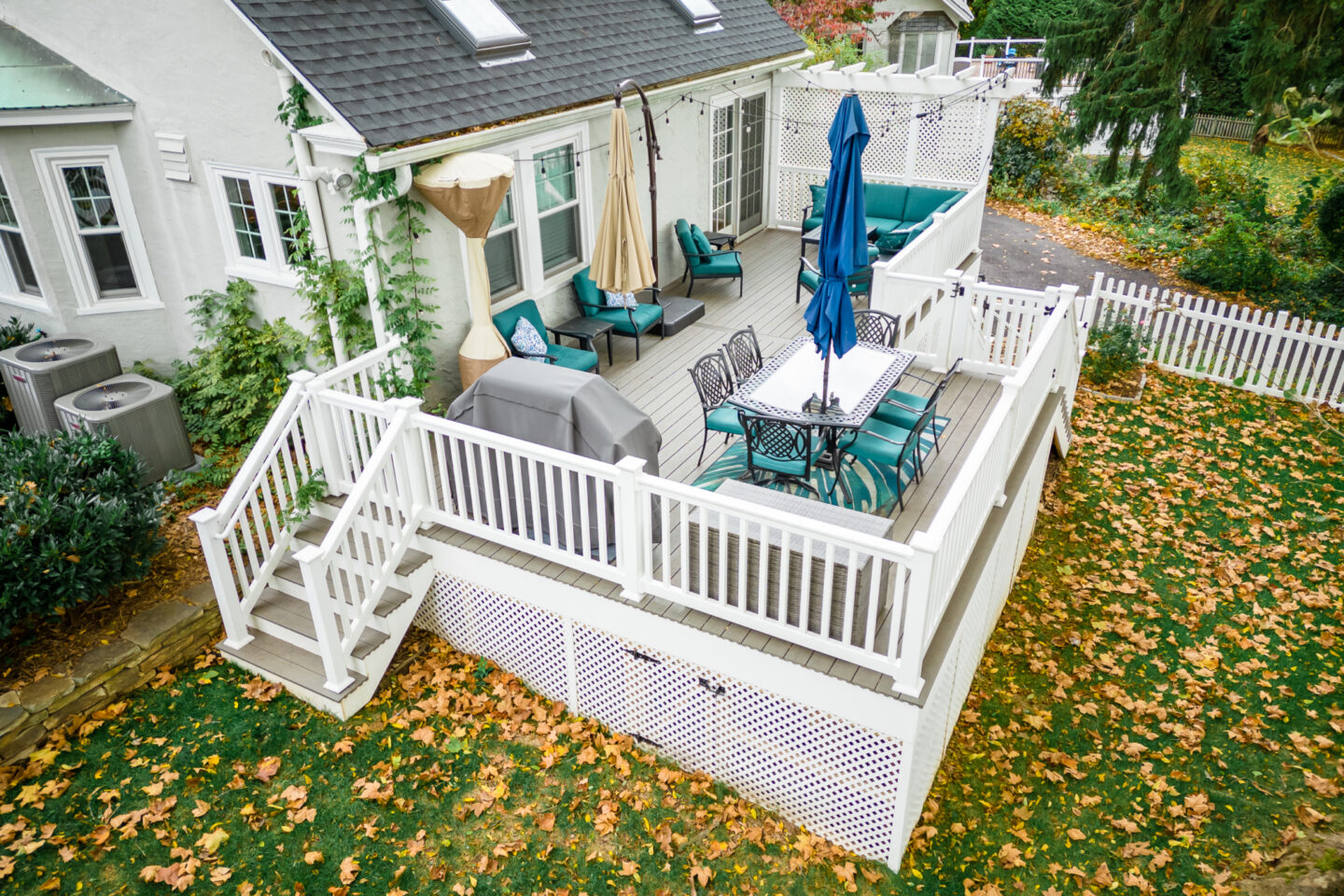 image of a deck in paoli pa built by integrous fences and decks featuring timbertech decking lattice skirting and privacy wall and white vinyl railing