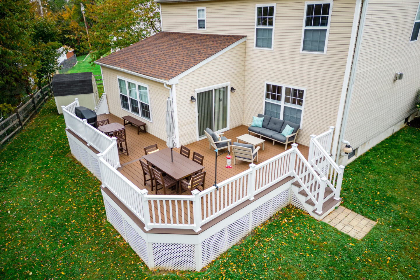 image of a deck with lattice skirting in media pa built by integrous fences and decks featuring timbertech decking white vinyl railing, and white vinyl underdeck lattice skirting with two steps to grade