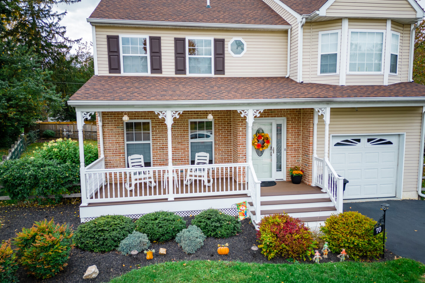 image of a porch with decorative details and lattice skirting in media pa built by integrous fences and decks featuring timbertech decking white vinyl railing and white vinyl with decorative spindles decorative white posts white decorative post to beam brackets and underdeck lattice skirting