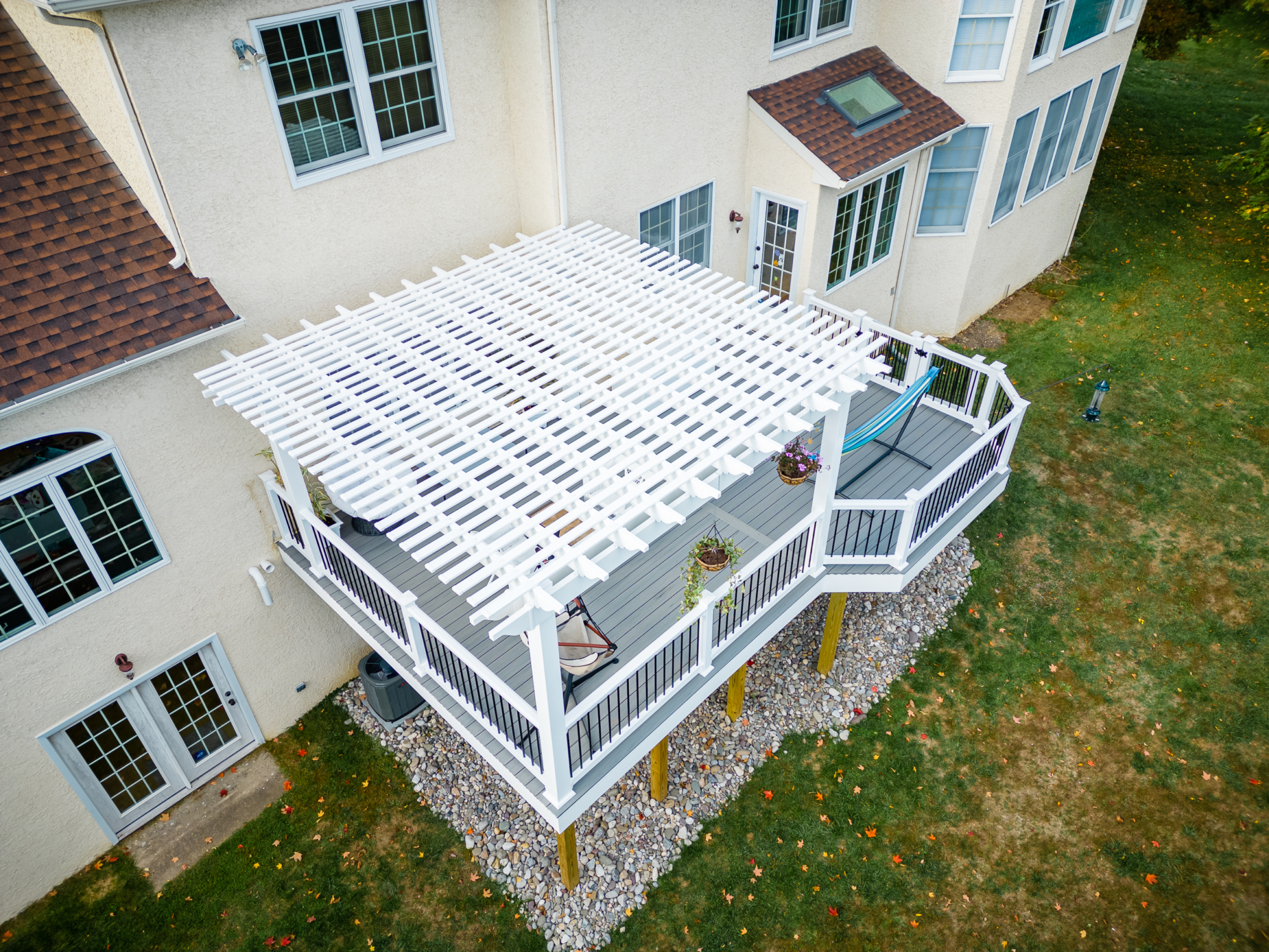 image of a deck with pergola in newtown square pa built by integrous fences and decks featuring a white vinyl pergola sea salt timbertech decking white vinyl railing with black aluminum railing