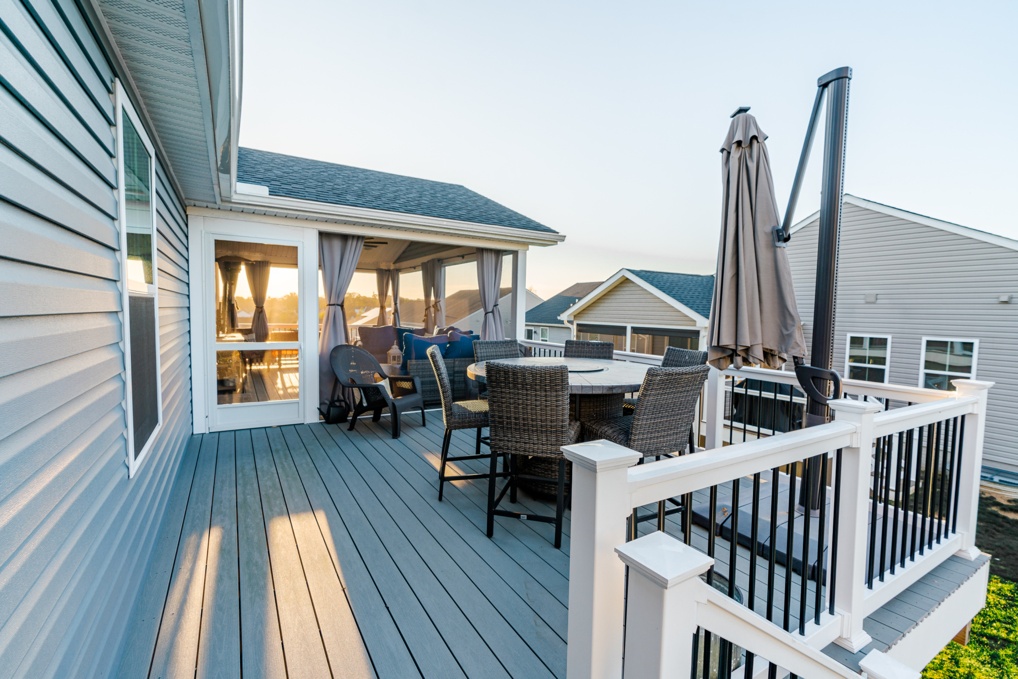 image of a deck with a screened in roof in coatesville pa built by integrous fences and decks featuring a screened in roof area an open deck timbertech decking white vinyl railing with black aluminum balusters and one set of stairs to grade