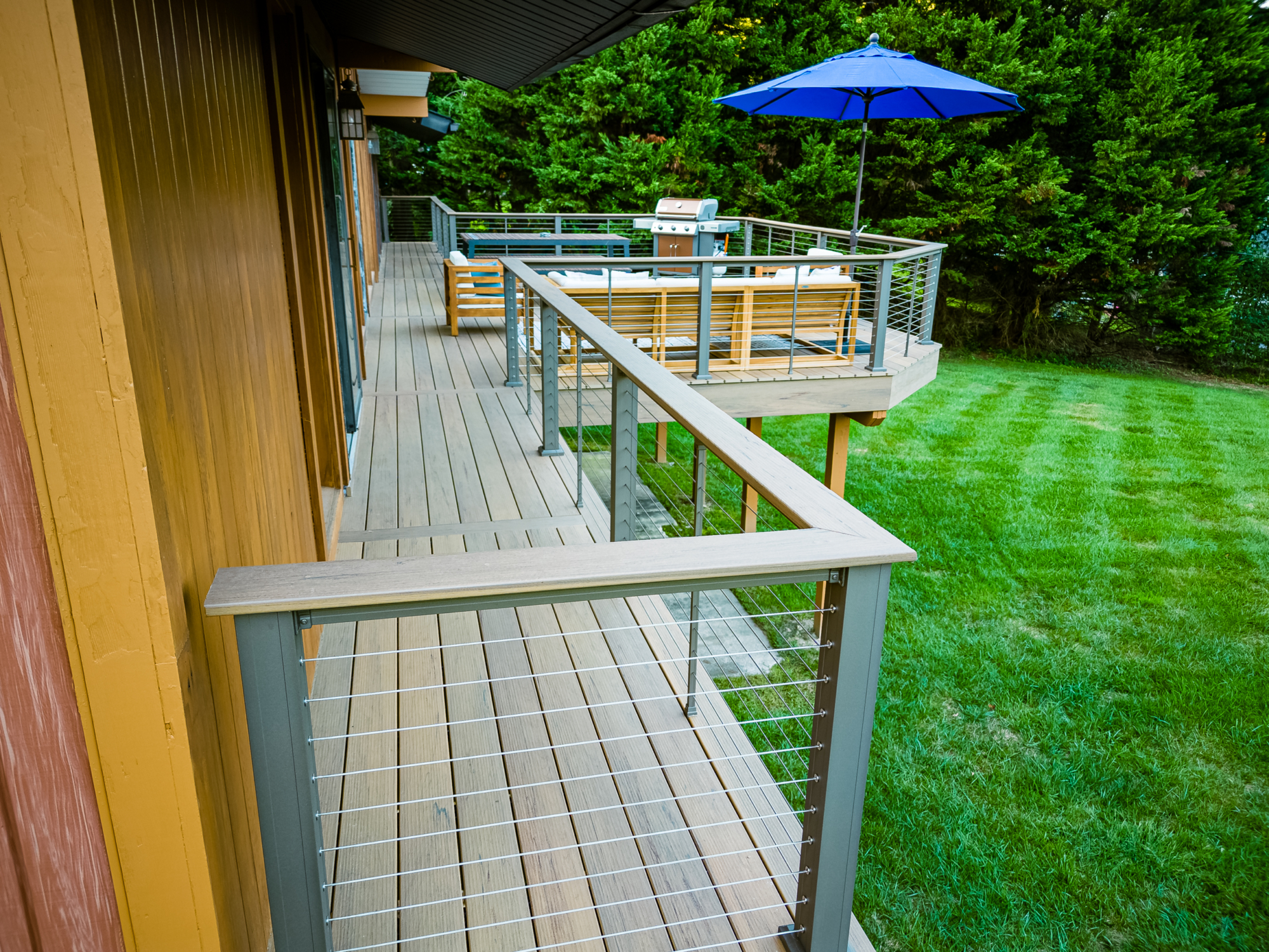 image of a modern deck in hockessin de built by integrous fences and decks featuring timbertech decking and keylink cable railing