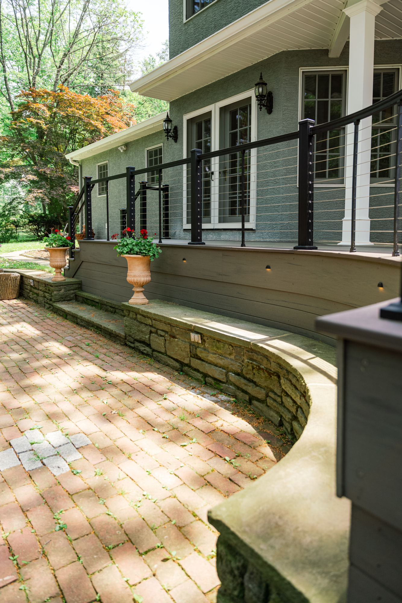 image of a large open deck in gladwyne pa built by integrous fences and decks featuring timbertech decking keylink cable railing and color matching fascia