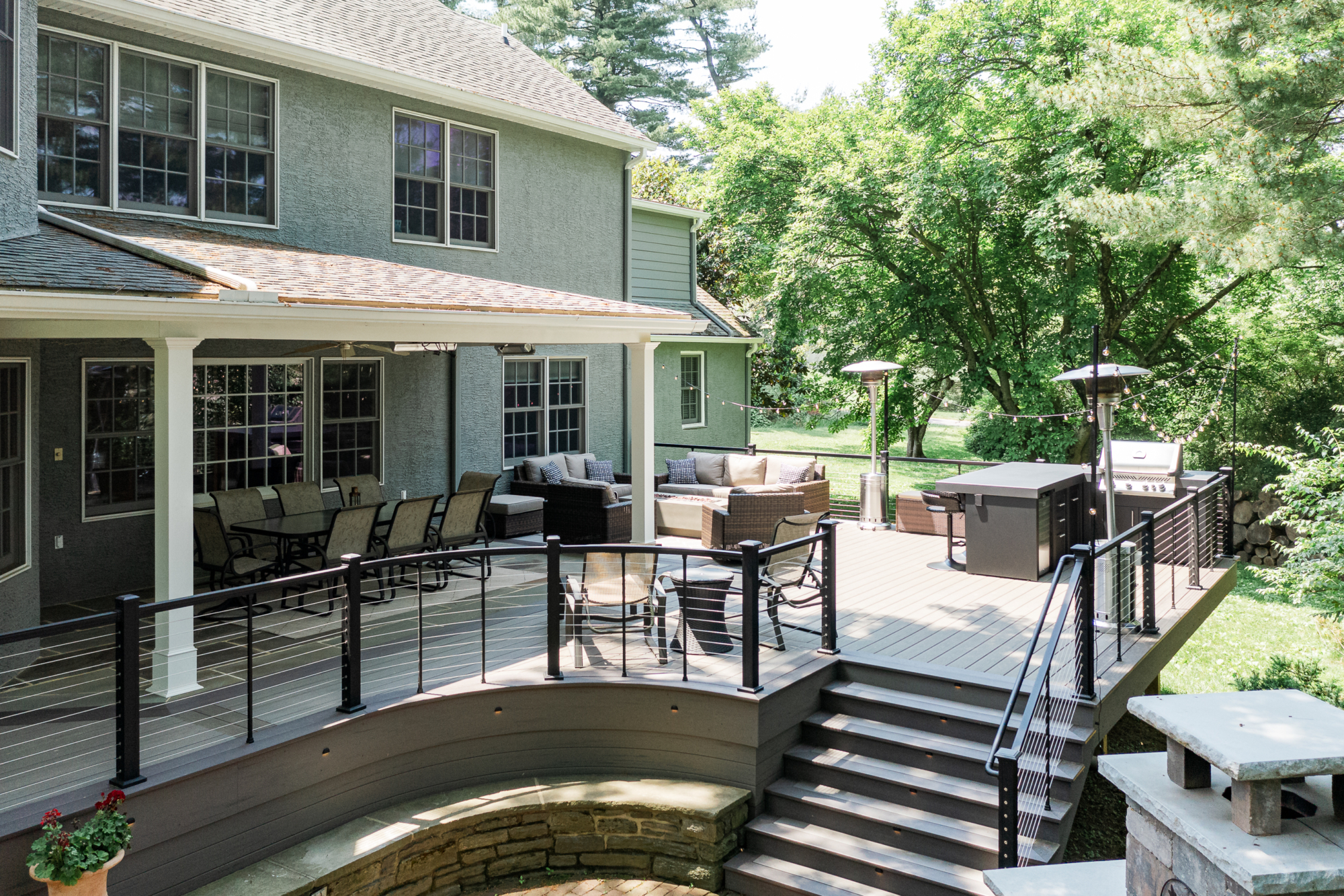 image of a large open deck in gladwyne pa built by integrous fences and decks featuring timbertech decking keylink cable railing and color matching fascia