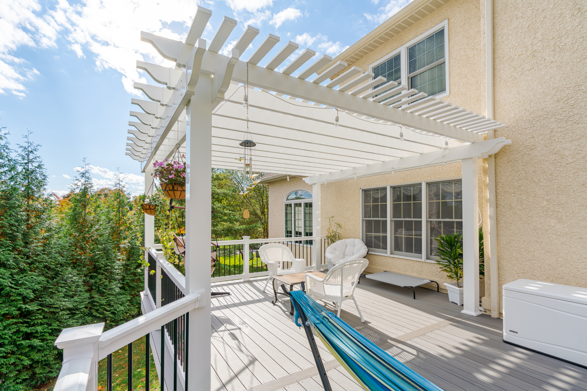 image of a deck with pergola in newtown square pa built by integrous fences and decks featuring a white vinyl pergola sea salt timbertech decking white vinyl railing with black aluminum railing