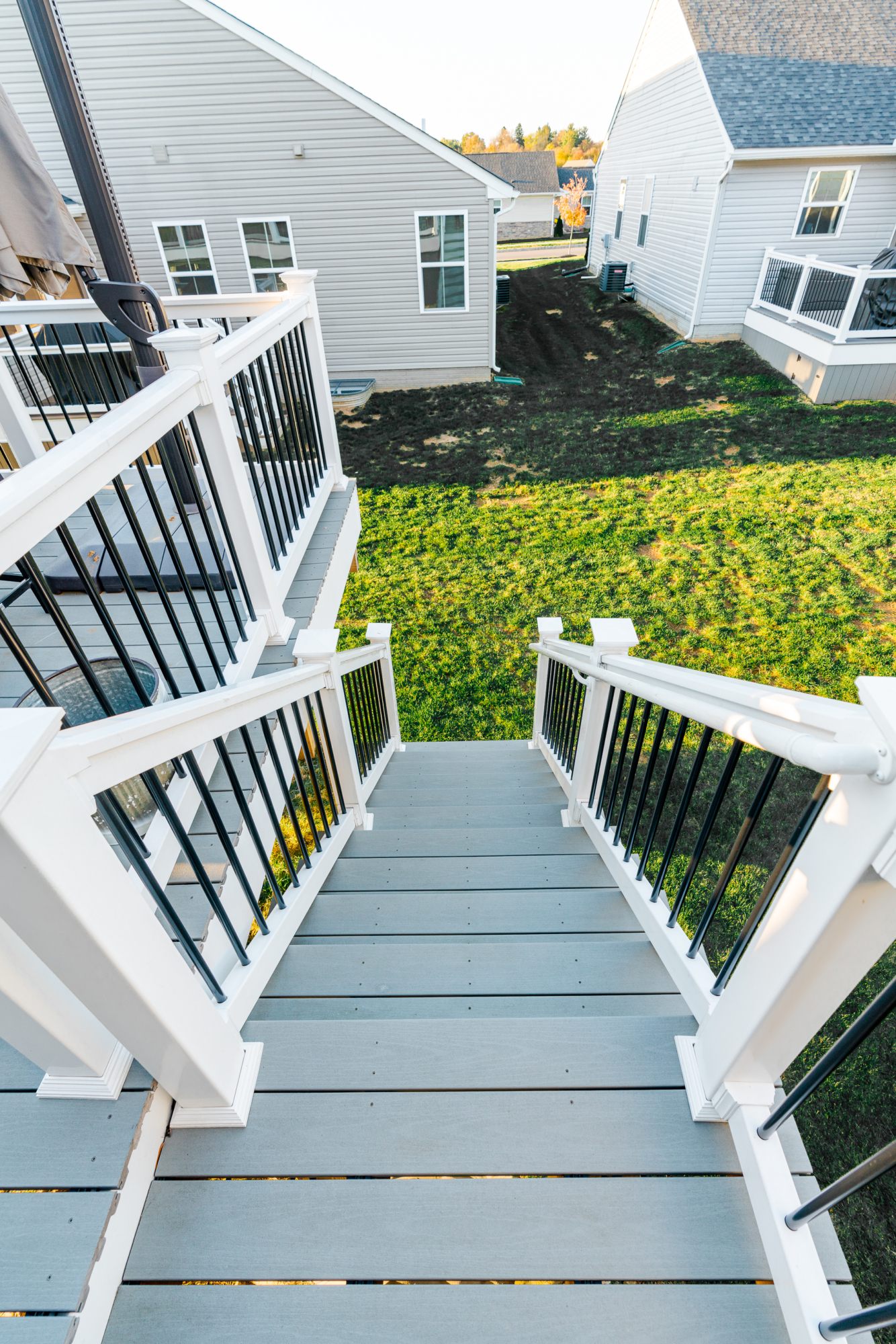 image of a deck with a screened in roof in coatesville pa built by integrous fences and decks featuring a screened in roof area an open deck timbertech decking white vinyl railing with black aluminum balusters and one set of stairs to grade