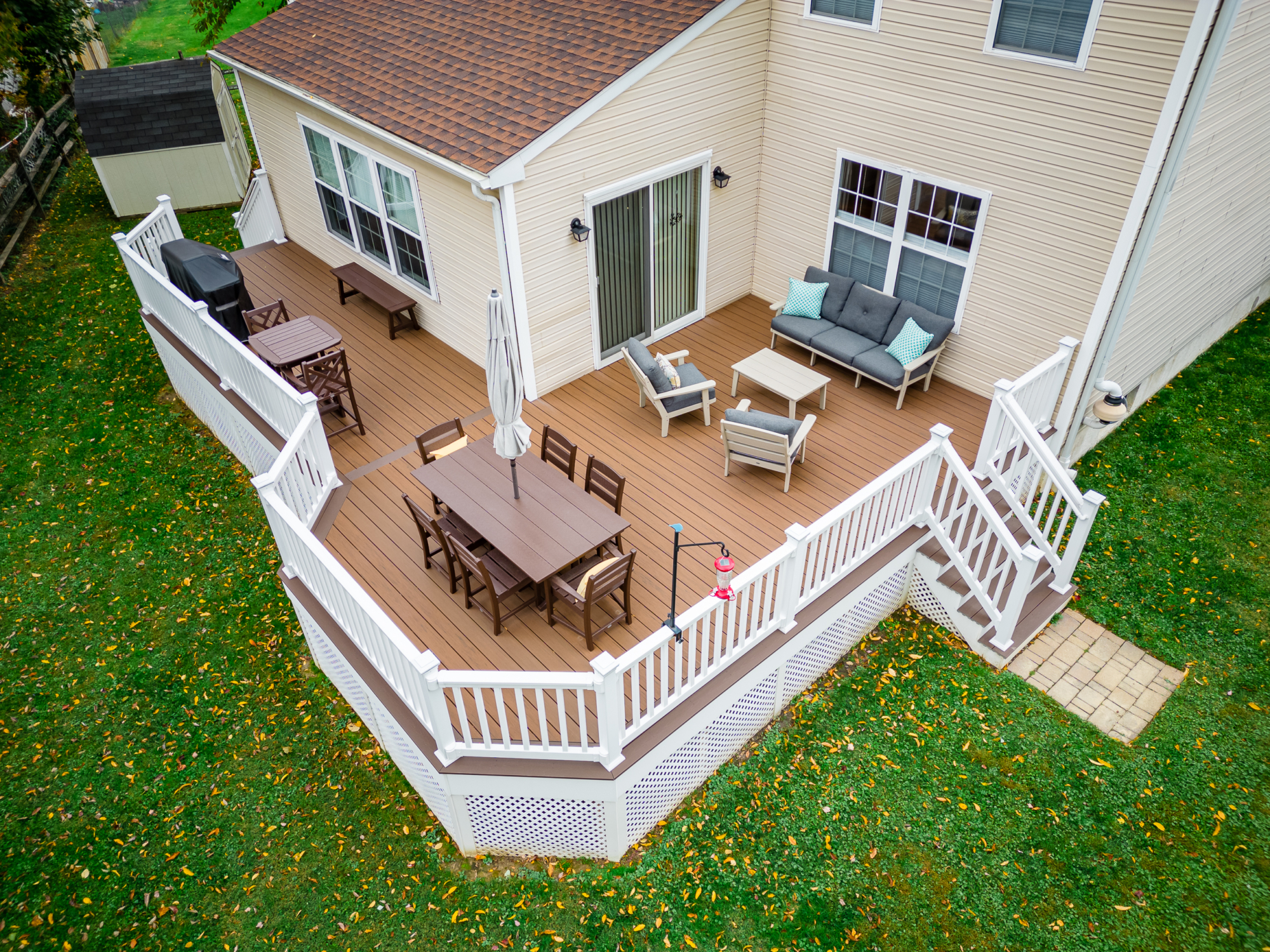 image of a deck with lattice skirting in media pa built by integrous fences and decks featuring timbertech decking white vinyl railing, and white vinyl underdeck lattice skirting with two steps to grade