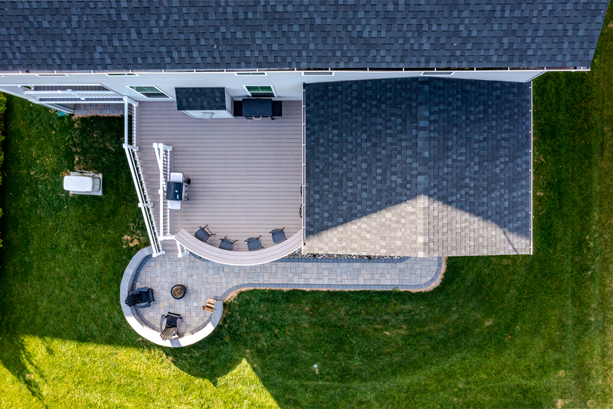 image of a deck in west bradford pa built by integrous fences and decks featuring a roof area a curved deck board bar timbertech decking and white vinyl railing with black aluminum balusters