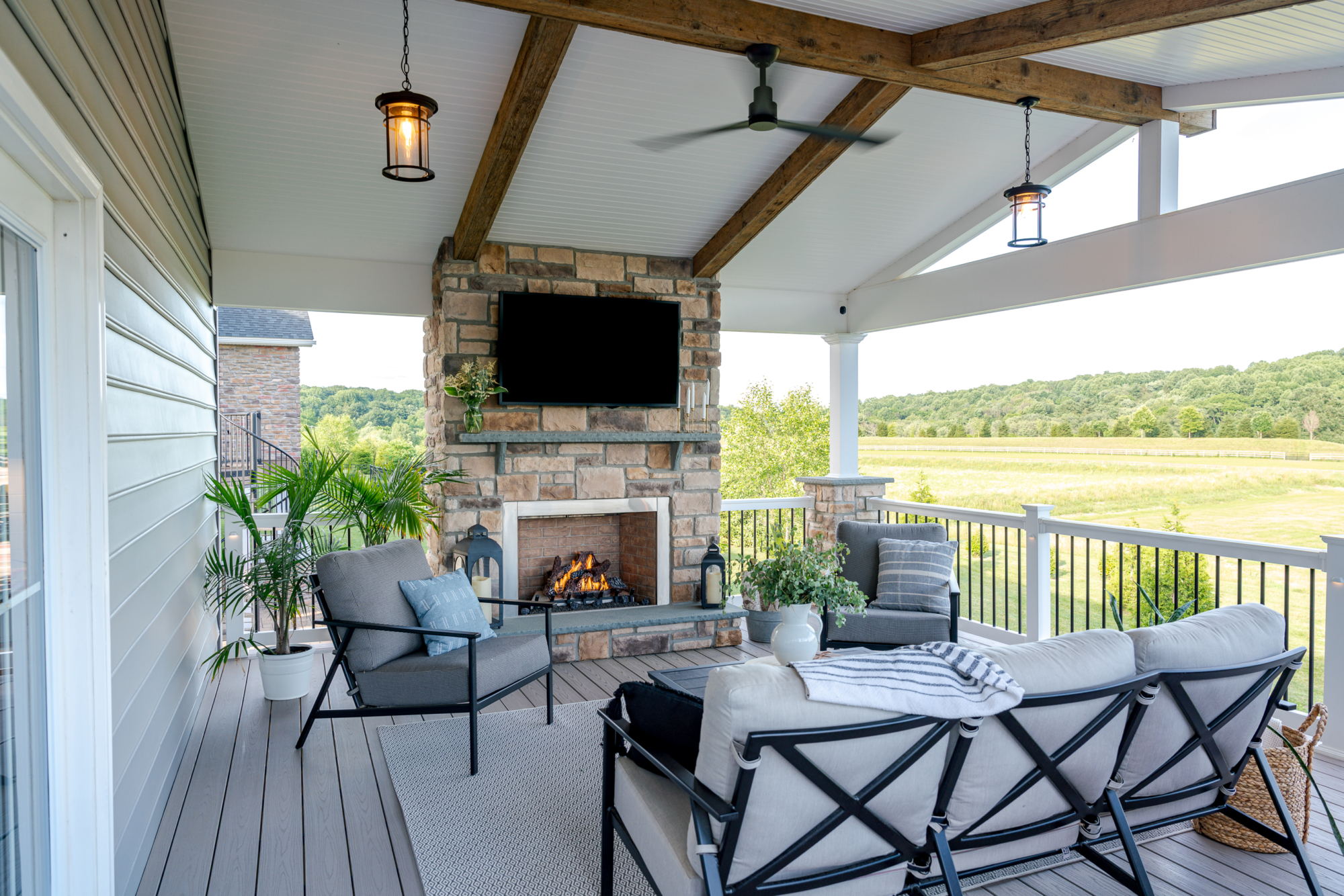 image of a deck in west bradford pa built by integrous fences and decks featuring a roof area a curved deck board bar timbertech decking and white vinyl railing with black aluminum balusters