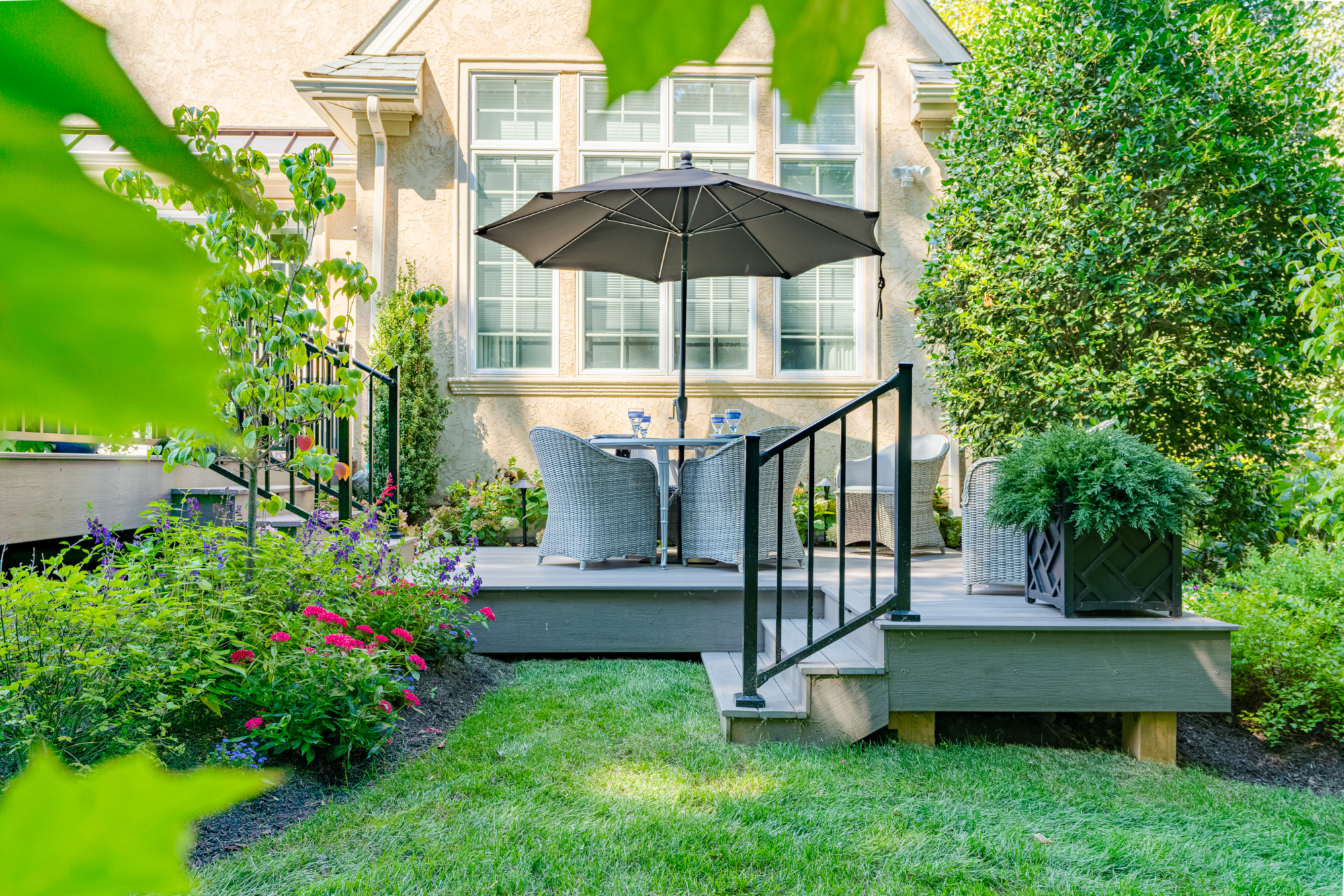image of a deck with timbertech ashwood decking and westbury black aluminum railing built by integrous fences and decks