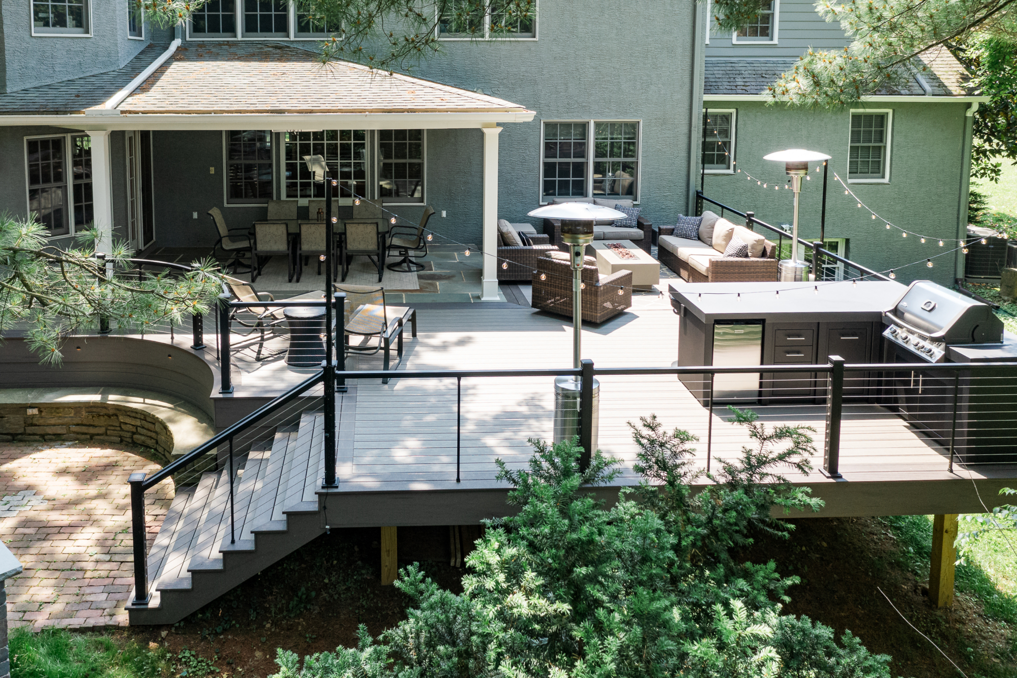 image of a large open deck in gladwyne pa built by integrous fences and decks featuring timbertech decking keylink cable railing and color matching fascia