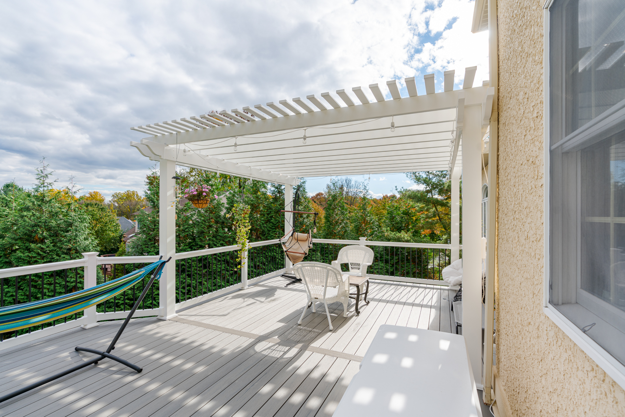 image of a deck with pergola in newtown square pa built by integrous fences and decks featuring a white vinyl pergola sea salt timbertech decking white vinyl railing with black aluminum railing
