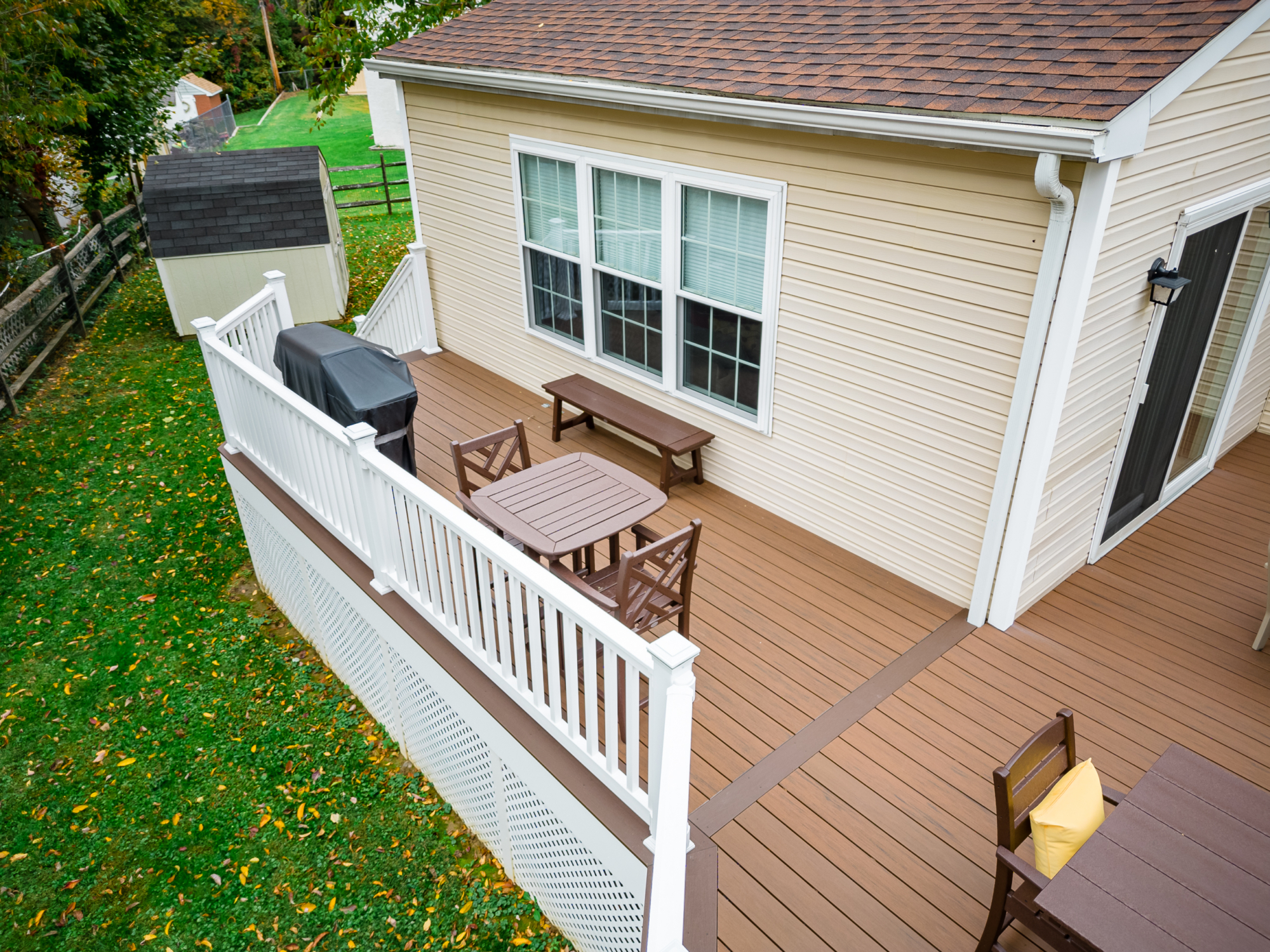 image of a deck with lattice skirting in media pa built by integrous fences and decks featuring timbertech decking white vinyl railing, and white vinyl underdeck lattice skirting with two steps to grade
