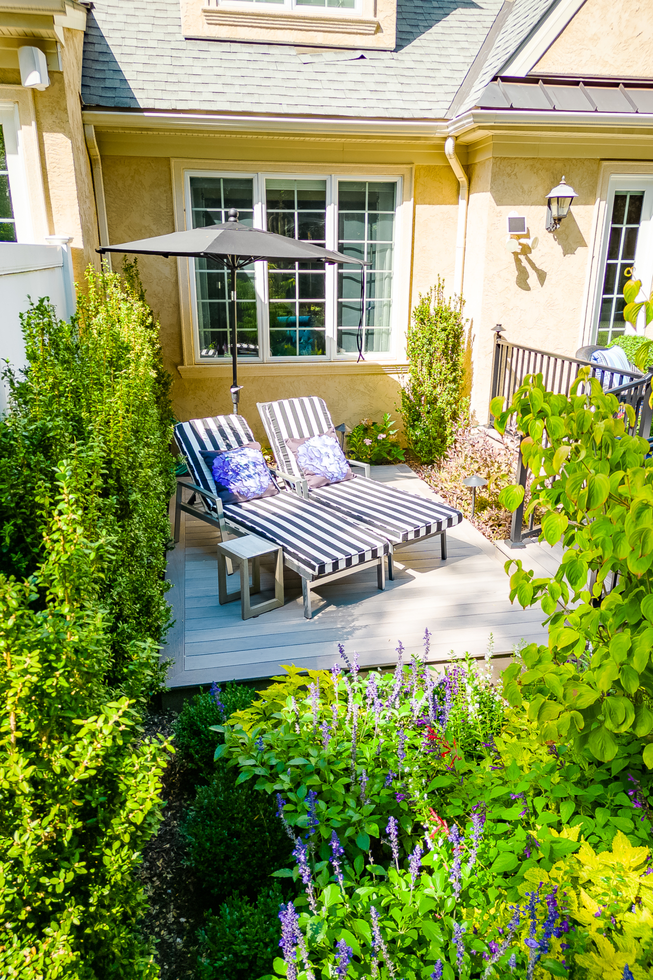 image of a timbertech deck built by integrous fences and decks surrounded by beautiful landscape design