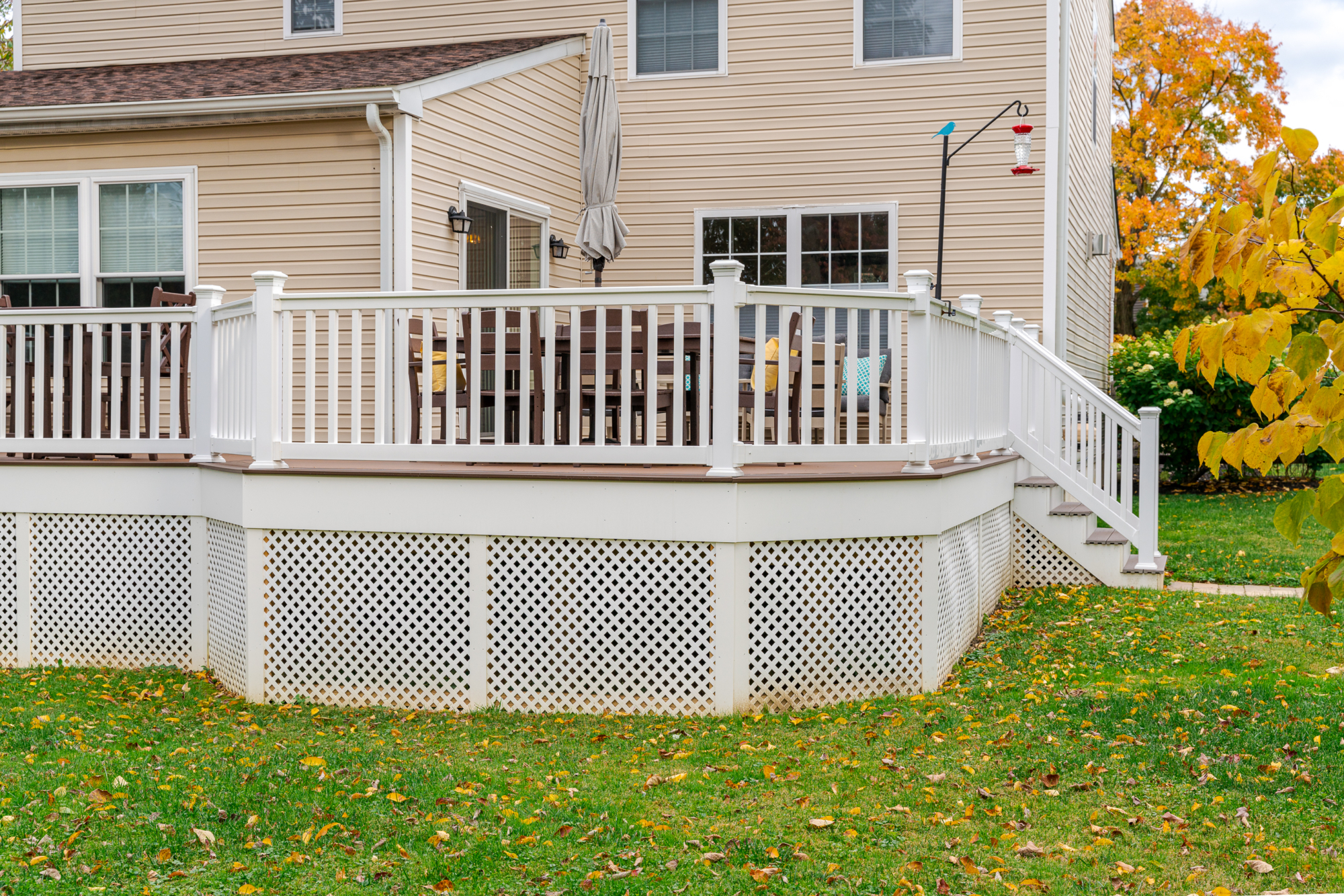 image of a deck with lattice skirting in media pa built by integrous fences and decks featuring timbertech decking white vinyl railing, and white vinyl underdeck lattice skirting with two steps to grade