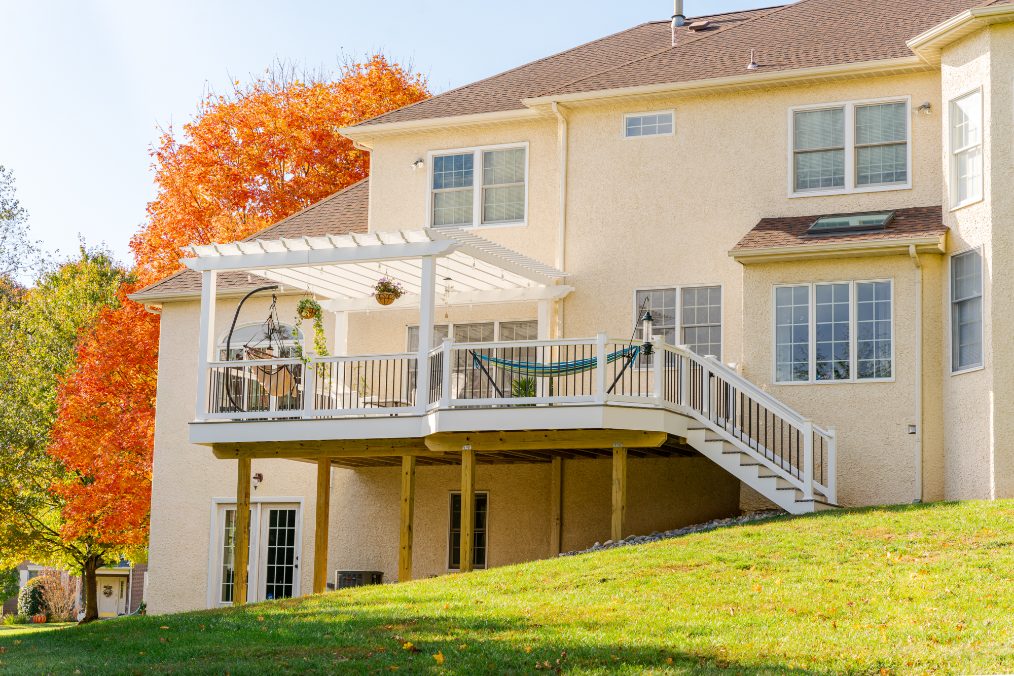 image of a deck with pergola in newtown square pa built by integrous fences and decks featuring a white vinyl pergola sea salt timbertech decking white vinyl railing with black aluminum railing
