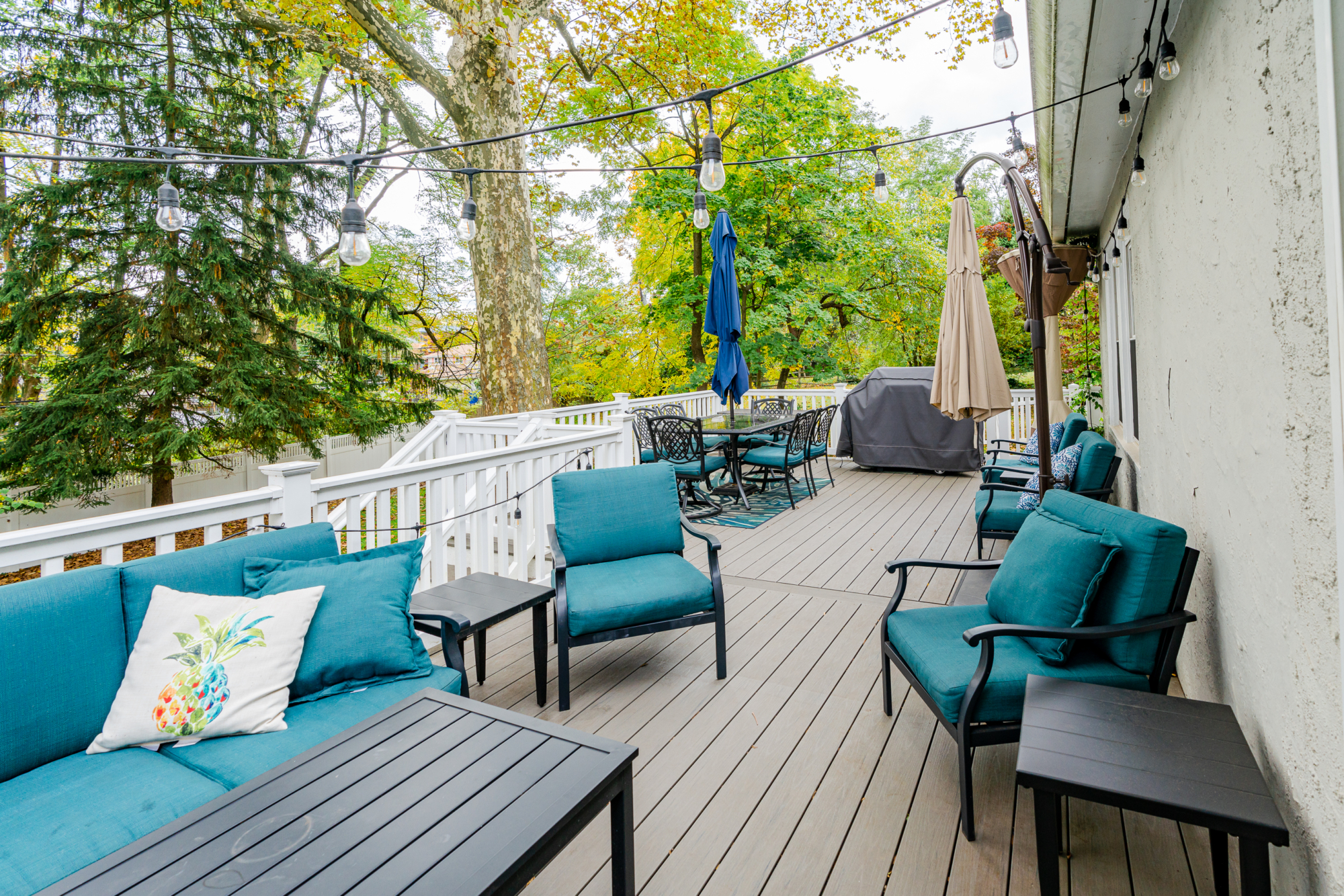 image of a deck in paoli pa built by integrous fences and decks featuring timbertech decking lattice skirting and privacy wall and white vinyl railing