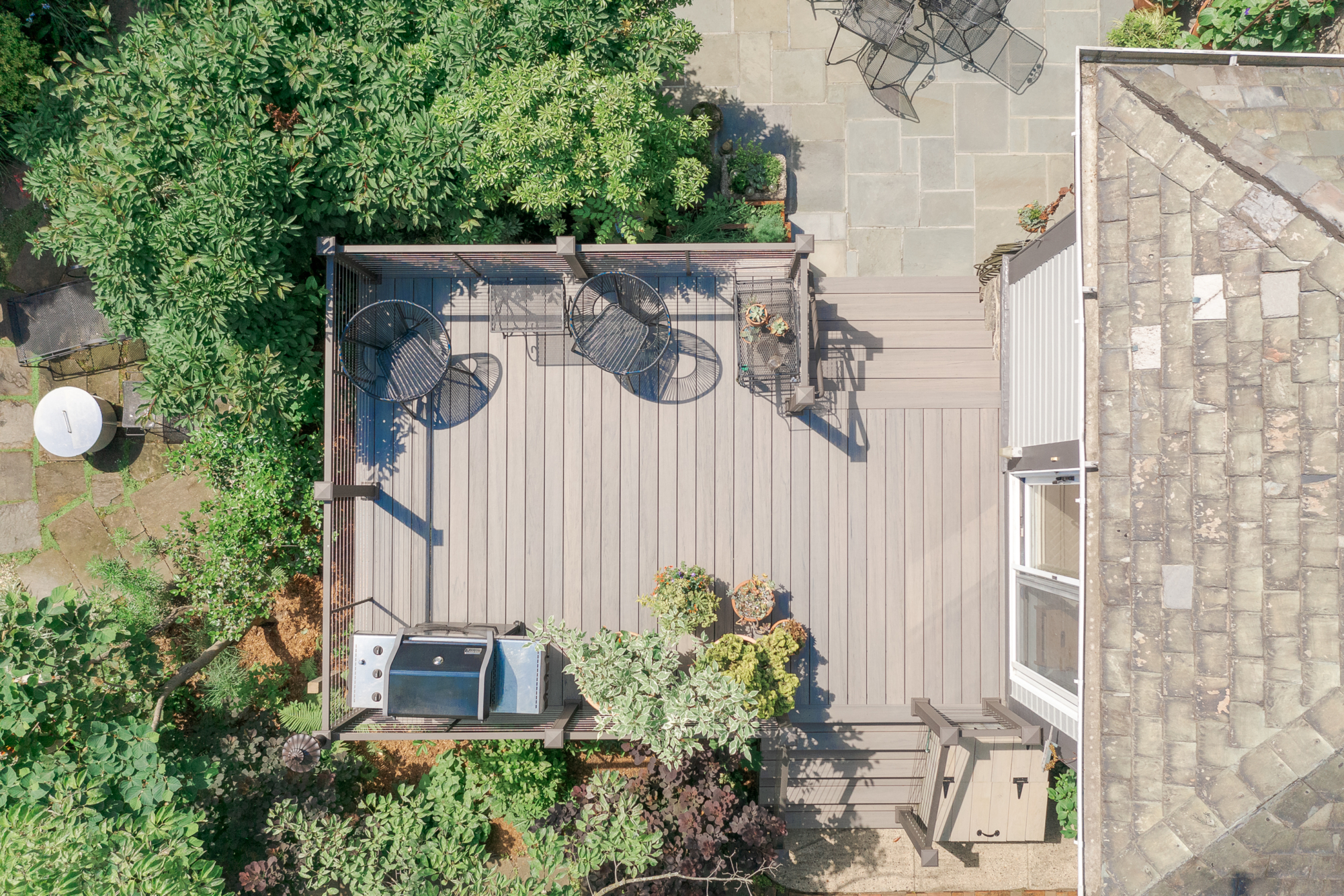 image of a deck in elkins pa built by integrous fences and decks featuring cable railing and timbertech decking located in a beautiful garden backyard