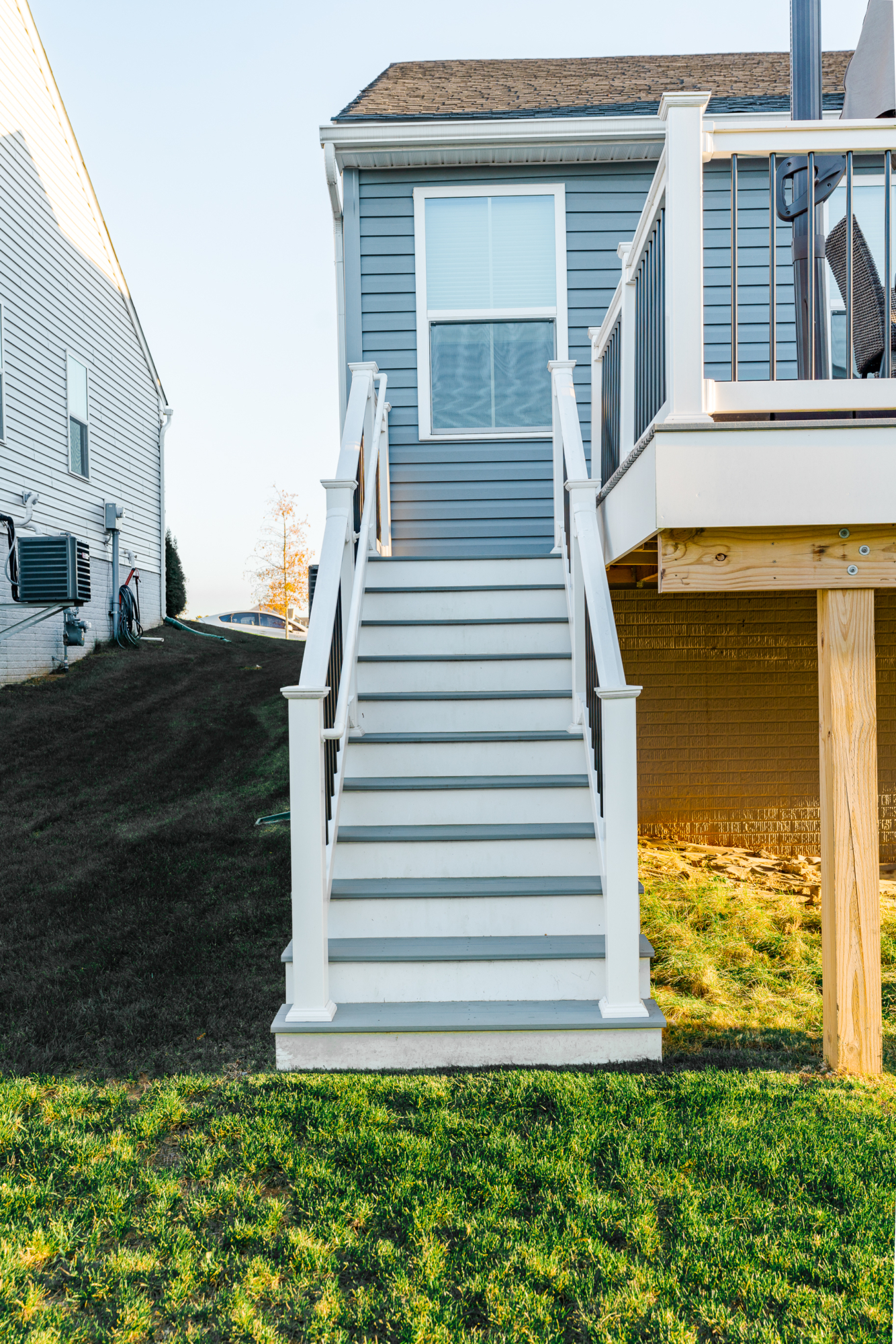 image of a deck with a screened in roof in coatesville pa built by integrous fences and decks featuring a screened in roof area an open deck timbertech decking white vinyl railing with black aluminum balusters and one set of stairs to grade