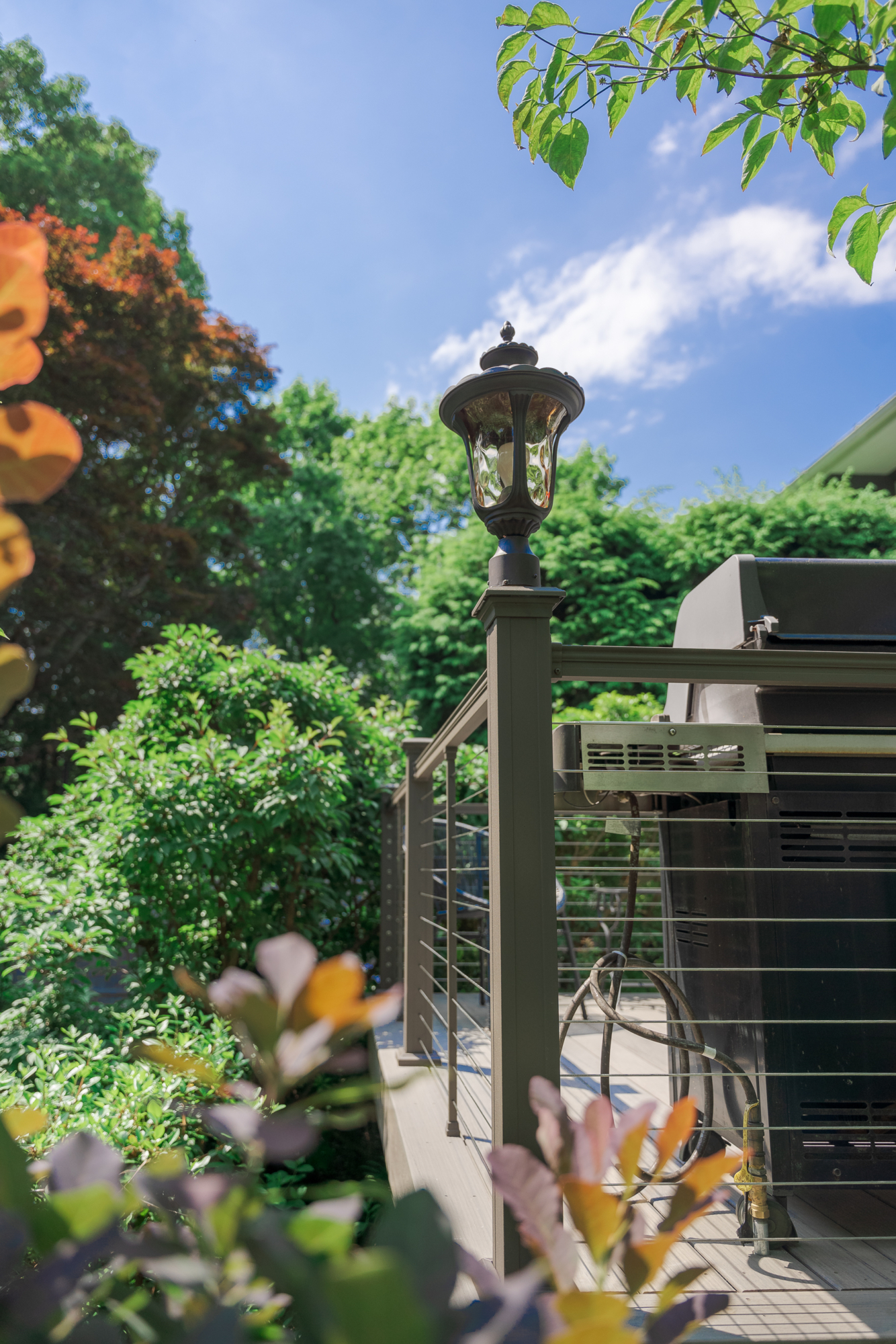 image of a deck in elkins pa built by integrous fences and decks featuring cable railing and timbertech decking located in a beautiful garden backyard