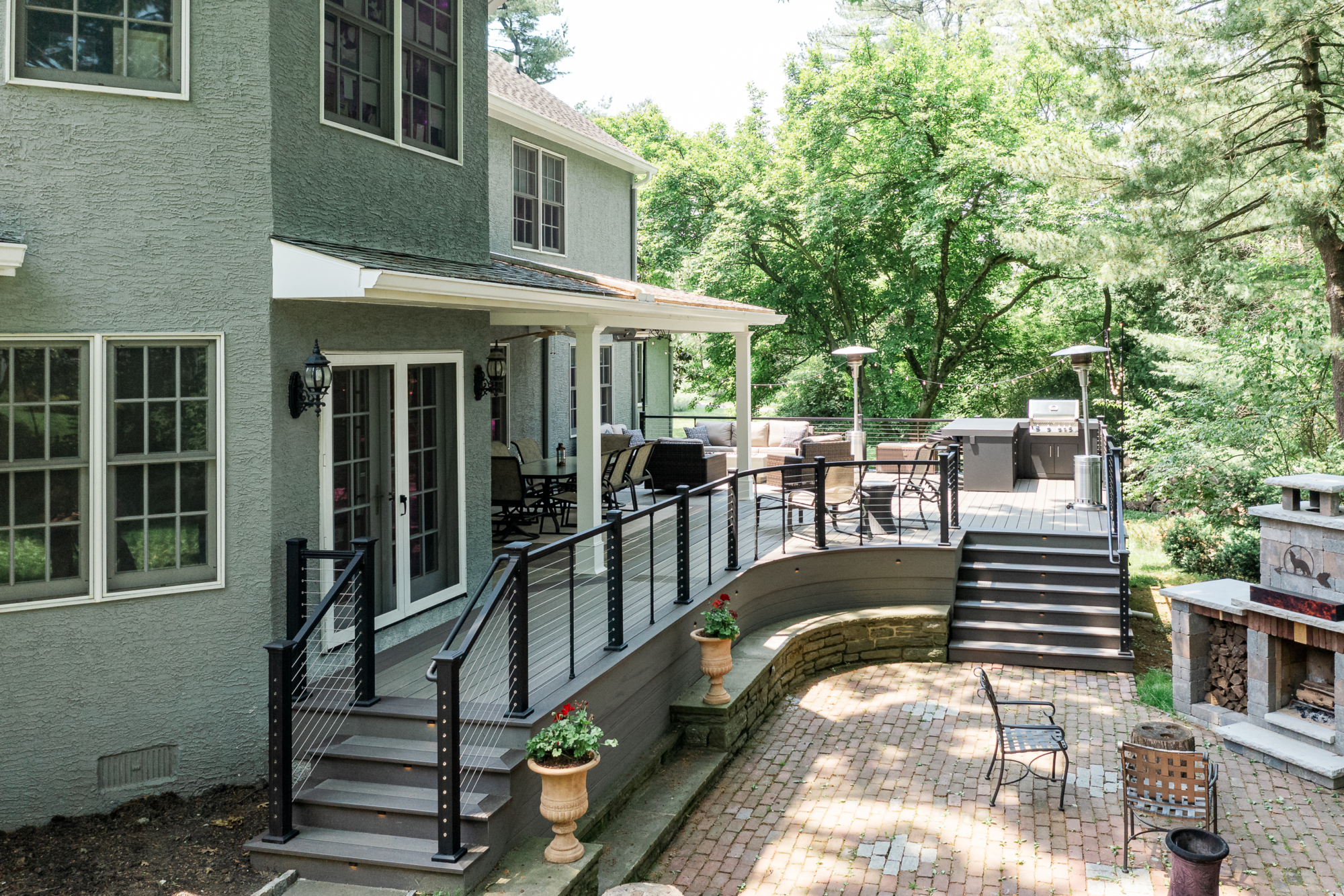 image of a large open deck in gladwyne pa built by integrous fences and decks featuring timbertech decking keylink cable railing and color matching fascia