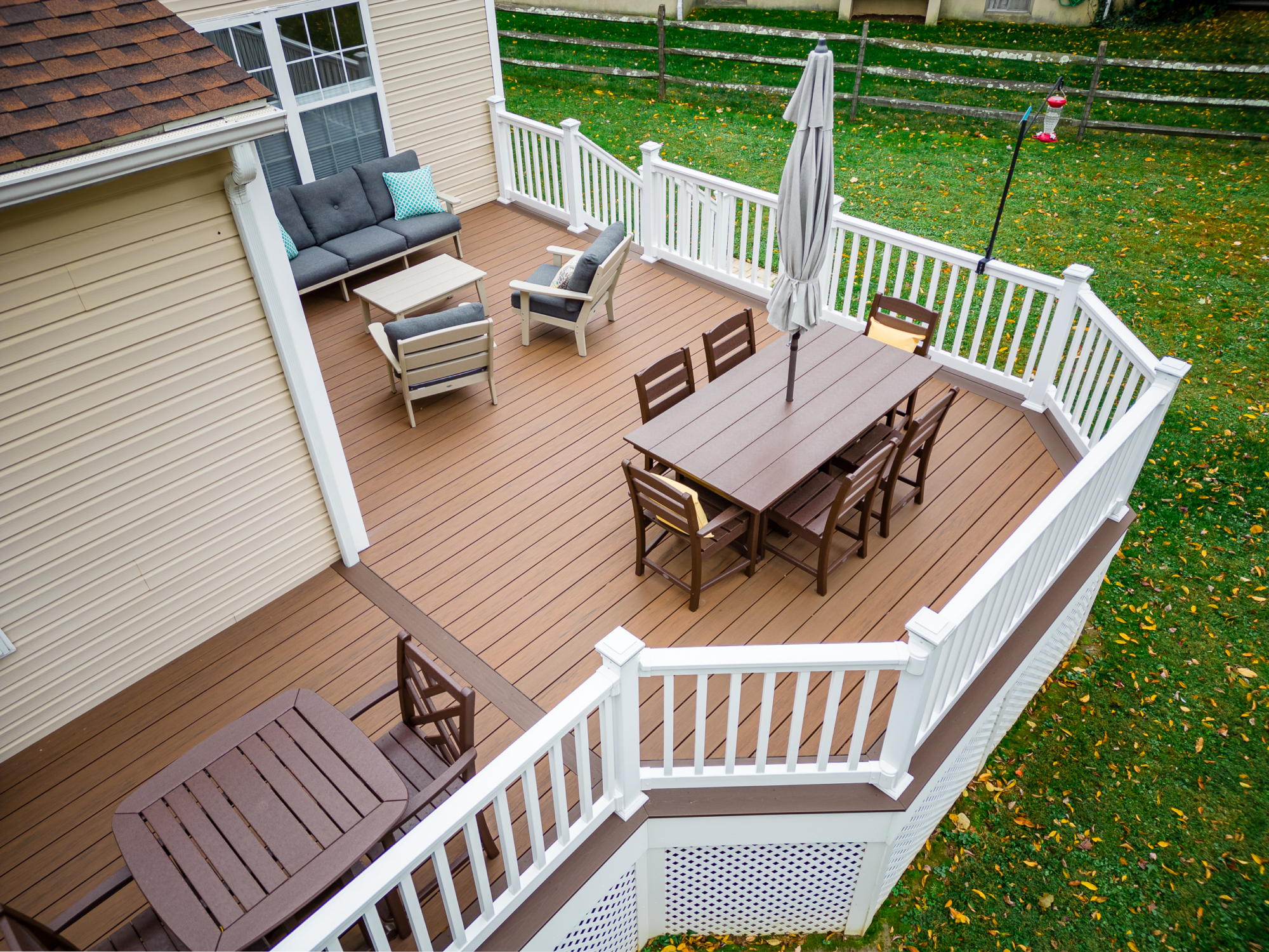 image of a deck with lattice skirting in media pa built by integrous fences and decks featuring timbertech decking white vinyl railing, and white vinyl underdeck lattice skirting with two steps to grade