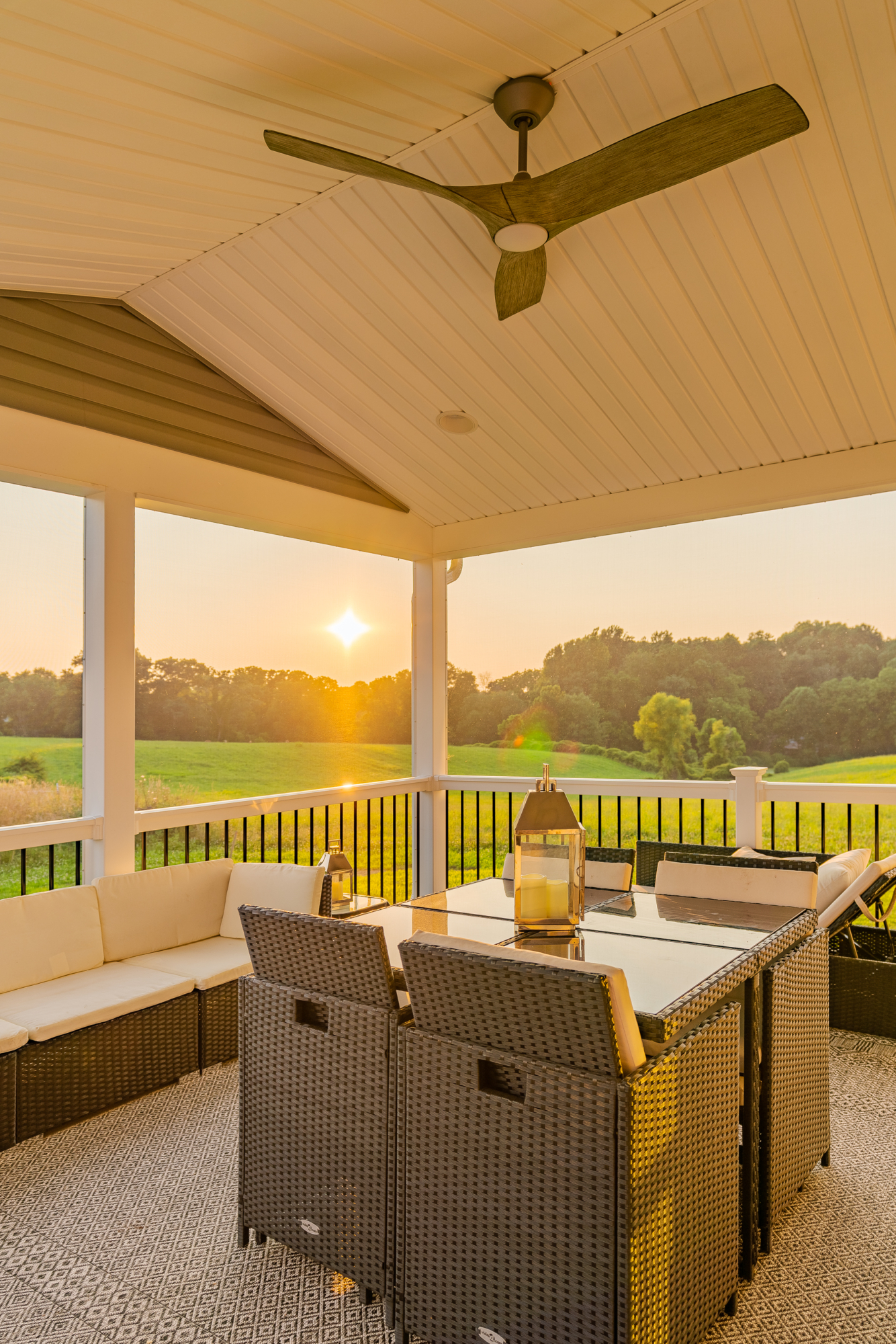 image of a deck with a screened in roof in avondale pa built by integrous fences and decks featuring a deck board bar timbertech decking and white vynl railing with black aluminum balusters