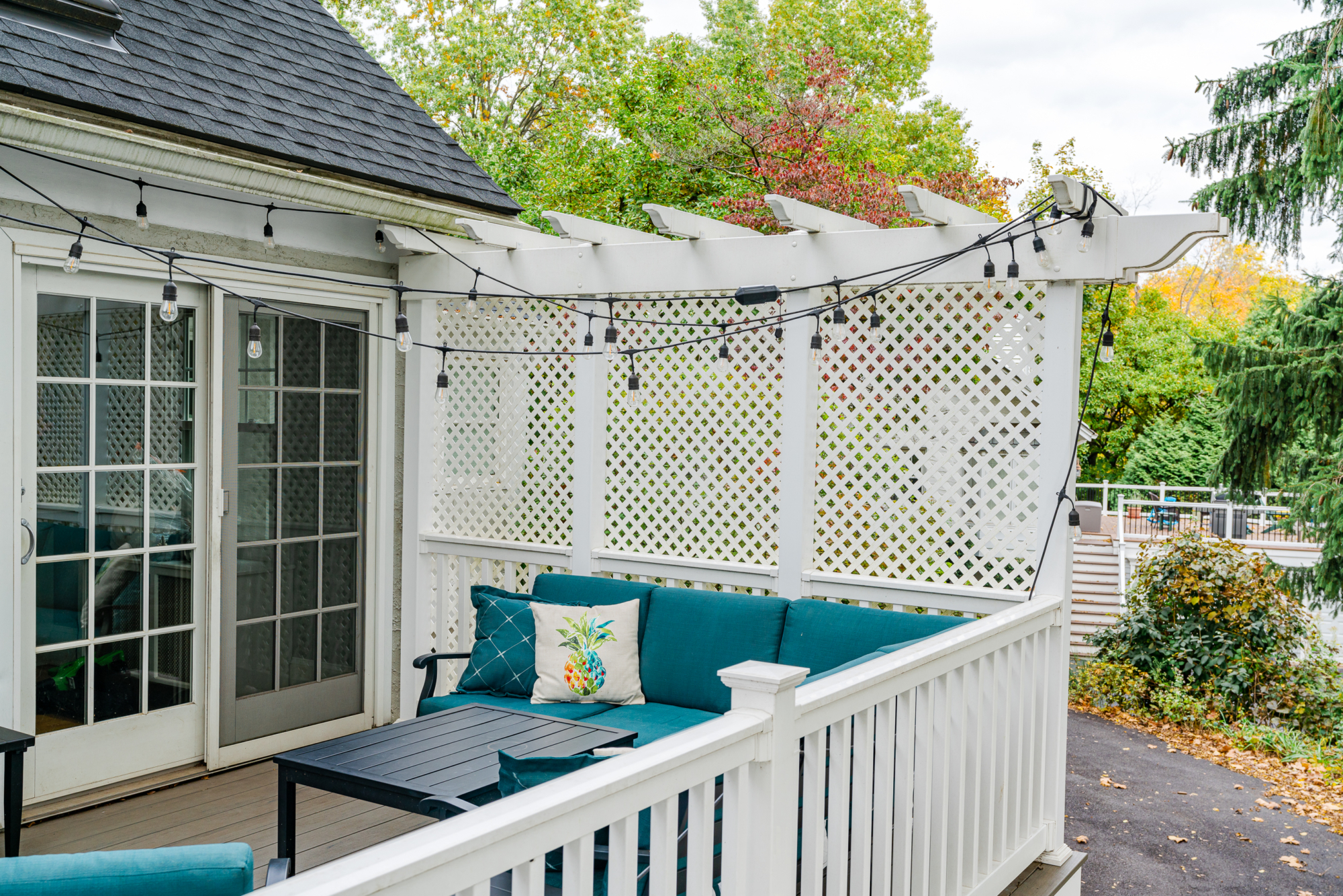 image of a deck in paoli pa built by integrous fences and decks featuring timbertech decking lattice skirting and privacy wall and white vinyl railing