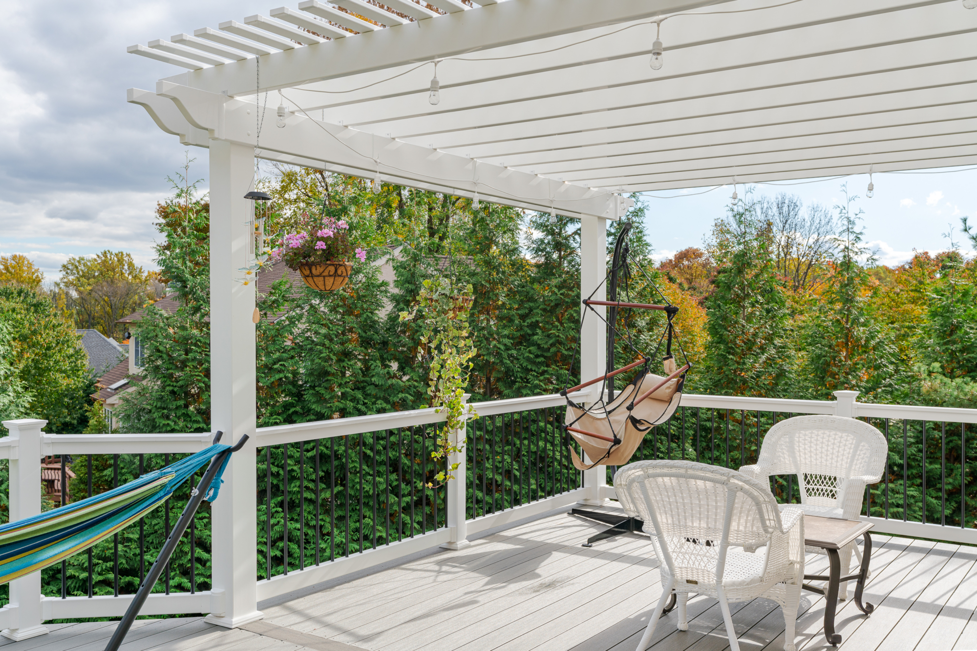 image of a deck with pergola in newtown square pa built by integrous fences and decks featuring a white vinyl pergola sea salt timbertech decking white vinyl railing with black aluminum railing